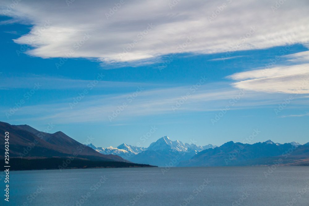 Scenic landscape panoramic view of the Lake Pukaki and Aoraki/Mount Cook on background. Tourist popular destination in South Island, New Zealand. Clear sky, sunny summer day. Travel concept.
