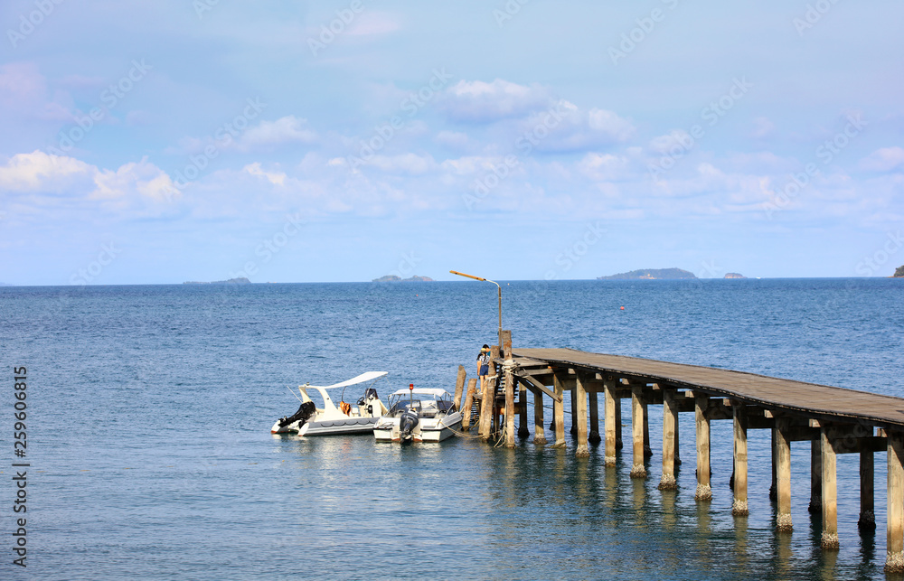 Speedboat and wooden bridge over to the sea