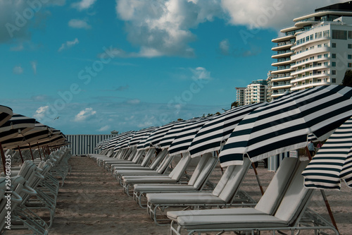 South Beach Miami: white and blue striped umbrellas and sunbeds on the beach. Beach life, vacation, holiday mood.
