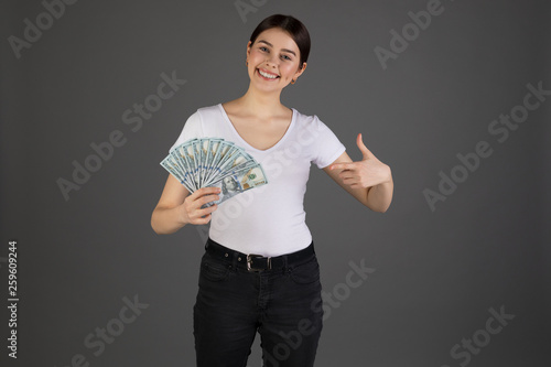 Close up portrait of happy eurupean woman holding money isolated on grey background photo