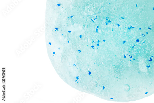 Cosmetic mint gel with scrub particles on a white background. Macro photography is suitable as a background for skin care  cosmetology  skin cleansers  products for the skin of the face.