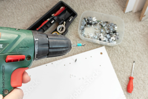 Wallpaper Mural Assembling furniture from chipboard, using a cordless screwdriver, close up Torontodigital.ca