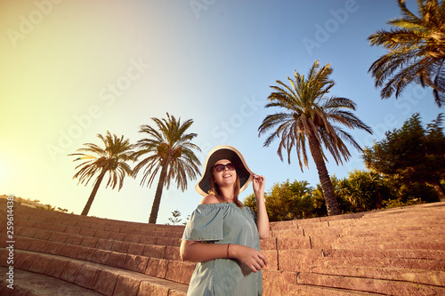 Young beautiful woman in beach hat walking on the steps of an ancient amphitheater at sunny day in Bodrum, Turkey. Vacation Outdoors Seascape Summer Travel Concept