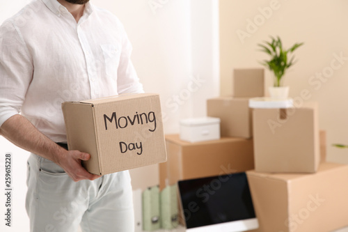 Man holding moving box in new office, closeup. Space for text © New Africa