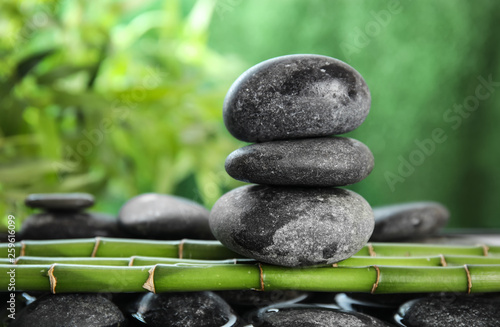 Zen stones on bamboo against blurred background