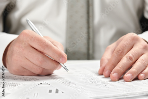 Businessman working in an office. Hands and documents closeup.