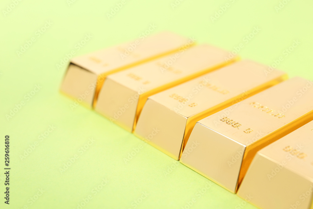 Shiny gold bars on color background, closeup Shiny gold bars on color background, closeup