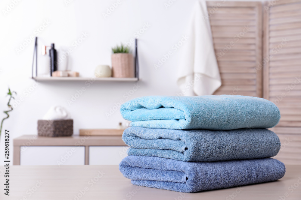 Stack of fresh towels on table in bathroom. Space for text Stack of fresh towels on table in bathroom. Space for text