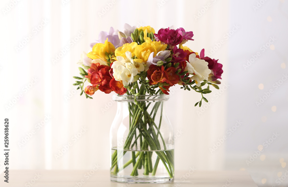 Obraz premium Beautiful spring bright freesia flowers in vase on table