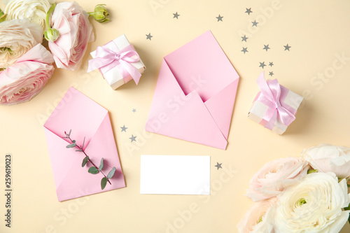 Flat lay composition with beautiful ranunculus flowers, card and envelope on color background. Space for text © New Africa