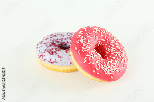 Vibrant composition of lush donut with colorful sprinkled icing, on bright background with a lot of copy space for text. Tasty but unhealthy food concept. Close up, flat lay, top view.