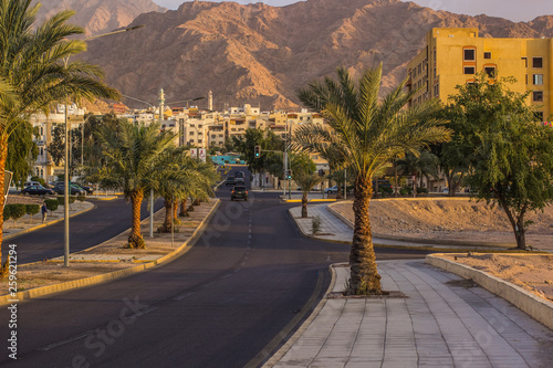 Middle East Jordanian south city Aqaba on Red sea coast line street urban outdoor photography with palm trees and car road