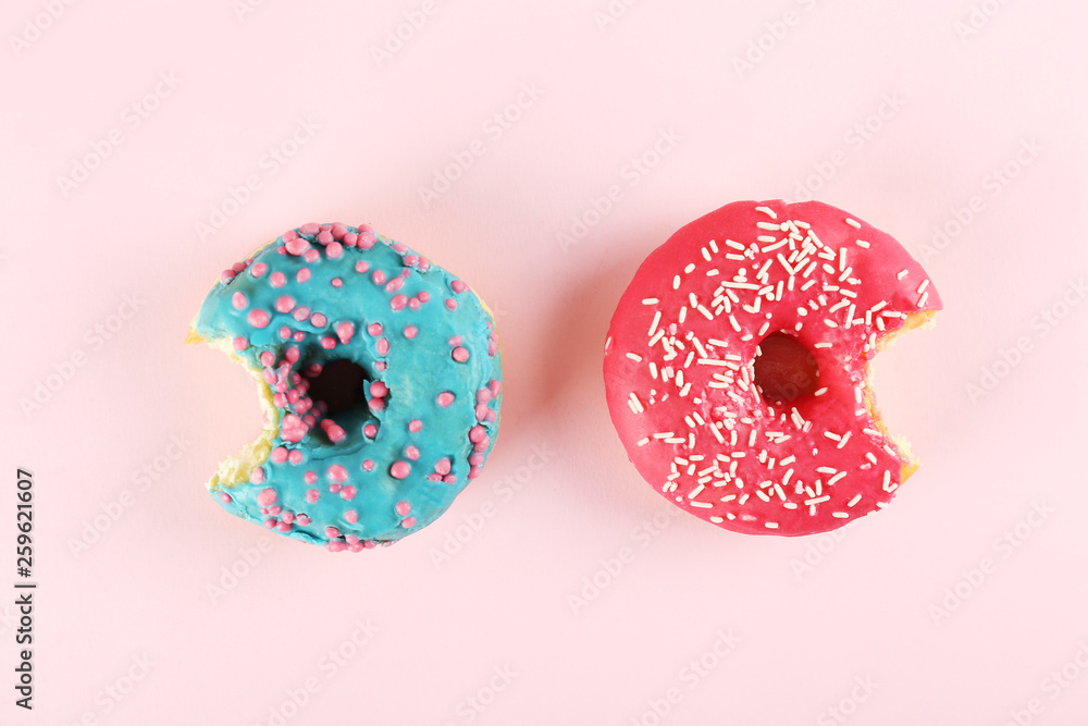 Vibrant composition of lush donut with colorful sprinkled icing, on bright background with a lot of copy space for text. Tasty but unhealthy food concept. Close up, flat lay, top view. Vibrant composition of lush donut with colorful sprinkled icing, on bright background with a lot of copy space for text. Tasty but unhealthy food concept. Close up, flat lay, top view.