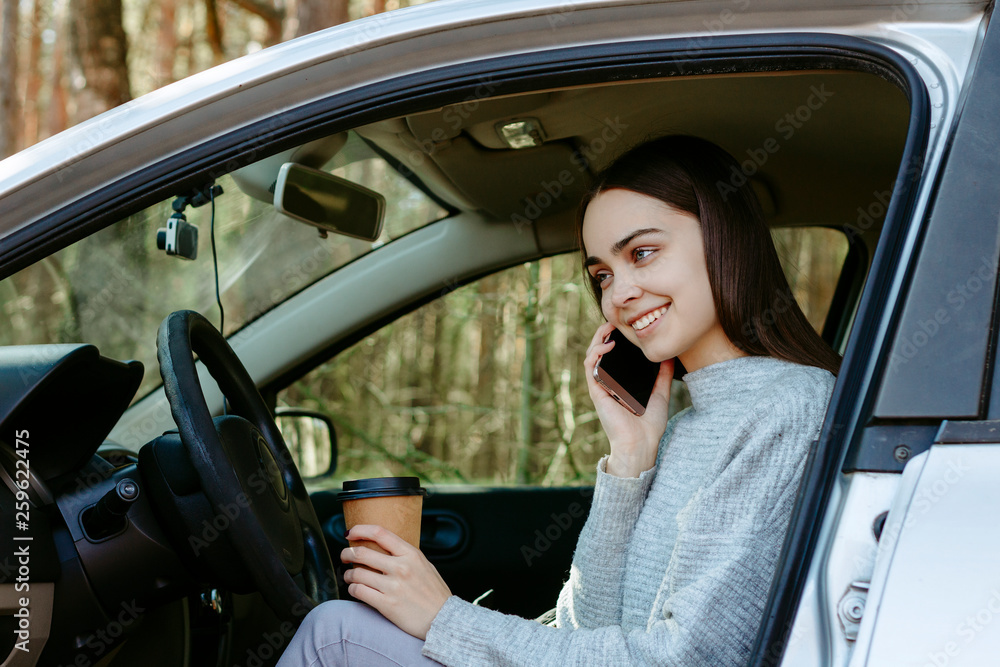 Young girl talks on the phone in a car