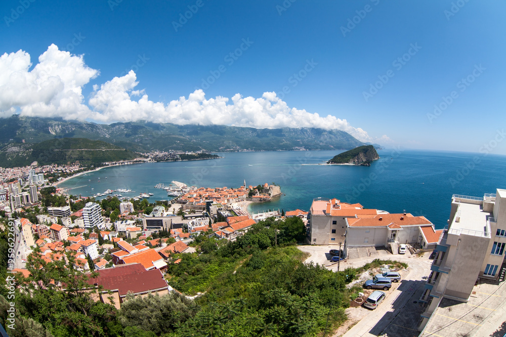 Panorama of Budva Riviera with city, old town with fortified walls and red roofs. View from above, wide angle. Adriatic sea, Montenegro, Europe