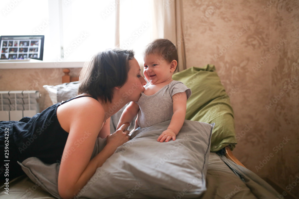 young mother brunette kiss and hugs baby daughter young mother brunette kiss and hugs baby daughter