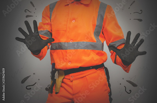 Guilty builder worker justifies and spreads his hands isolated on blue background. Construction mistake. photo