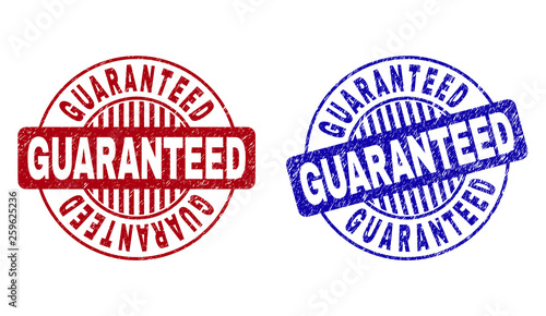 Grunge GUARANTEED round stamp seals isolated on a white background. Round seals with grunge texture in red and blue colors. Vector rubber imprint of GUARANTEED tag inside circle form with stripes.