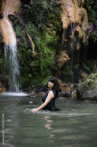 Beautiful  mature Portuguese woman standing in a hot spring in Caldeira Velha  Sao Miguel  Azores  Portugal.