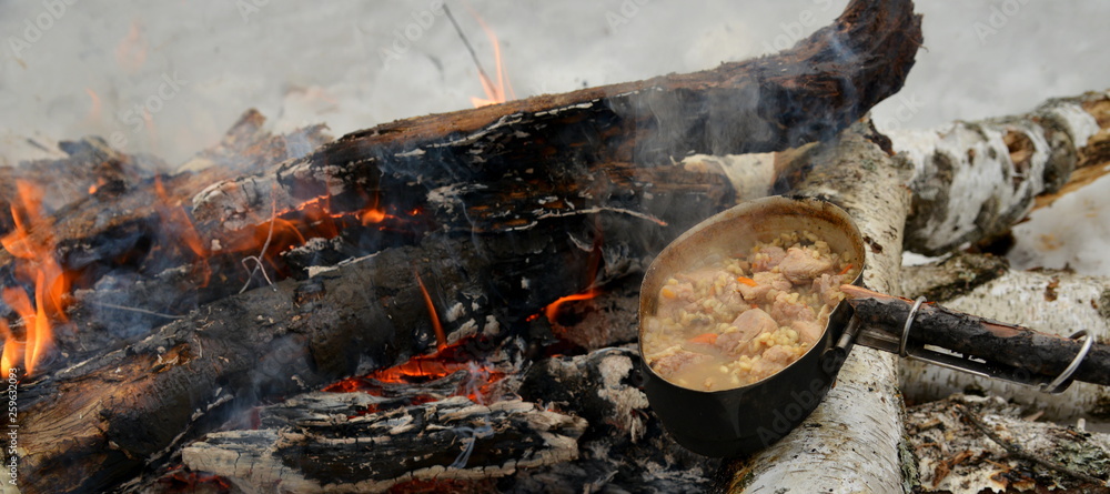 preparing food on a fire winter in the forest