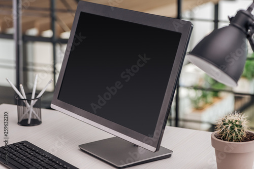 selective focus of computer with blank screen at workplace in office