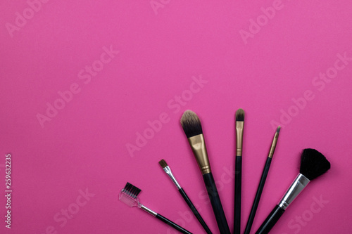 Make up brushes on a hot pink background