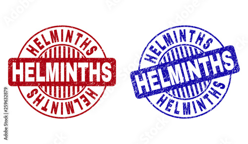 Grunge HELMINTHS round stamp seals isolated on a white background. Round seals with grunge texture in red and blue colors. Vector rubber watermark of HELMINTHS caption inside circle form with stripes.