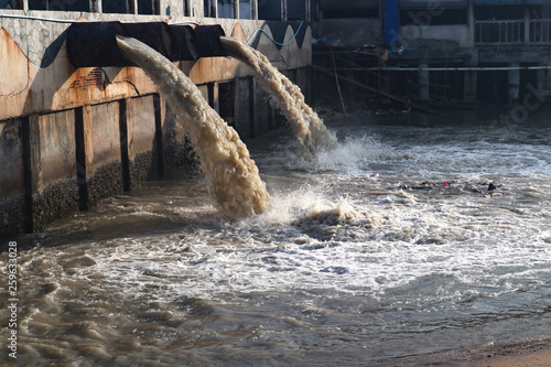 Waste water discharge pipe into canal and sea photo