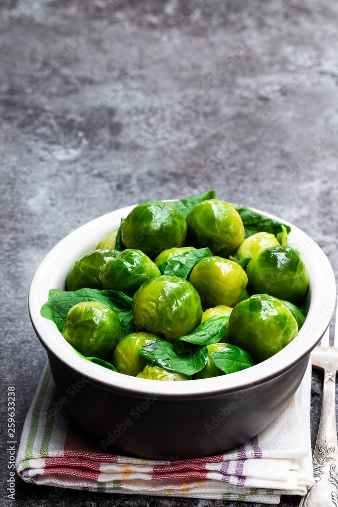 Cooked brussels sprouts with spinach on gray table Cooked brussels sprouts with spinach on gray table