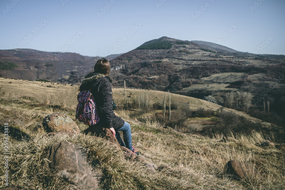 Fototapeta premium Young woman backpacker enjoy the view at mountain peak and peaceful environment