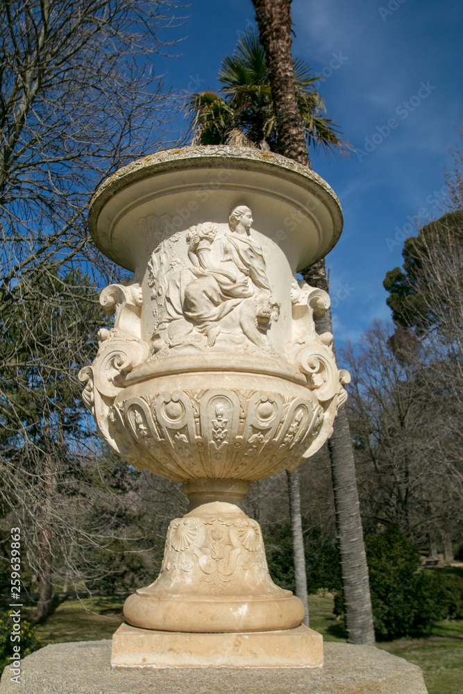 Obraz premium Roman Stone vase in the old classical style with trees in the Campo del Moro park, Madrid