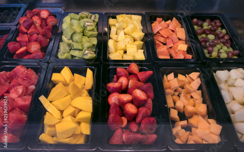 Slides of diferents tropical fruits at the market. Watermelon, papaya, mango, melon, kiwi and strawberrys. photo