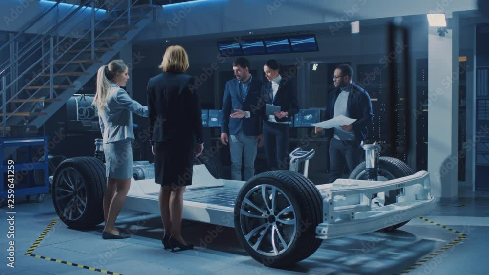 Diverse Team of Automobile Design Engineers Introducing Futuristic Autonomous Electric Car Platform Chassis to a Group of Investors and Businesspeople. Vehicle Frame with Wheels, Engine and Battery Diverse Team of Automobile Design Engineers Introducing Futuristic Autonomous Electric Car Platform Chassis to a Group of Investors and Businesspeople. Vehicle Frame with Wheels, Engine and Battery