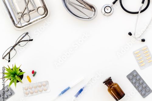 Pills and instruments of doctor frame on white background top view copyspace