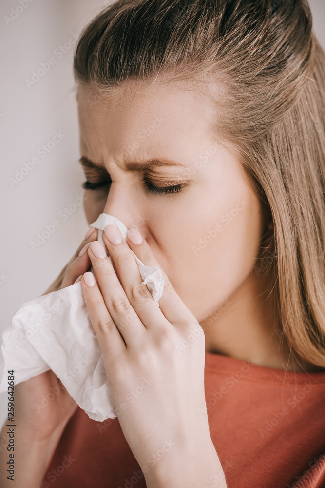 close up of beautiful blonde girl sneezing with closed eyes in tissue close up of beautiful blonde girl sneezing with closed eyes in tissue