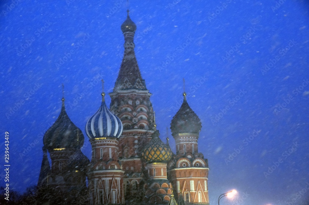 Obraz premium Saint Basils cathedral on the Red Square in Moscow at snowstorm. Color night photo.