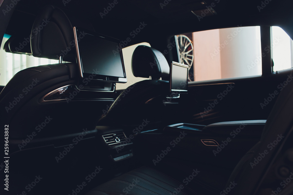 Car inside. Interior of prestige luxury modern car. Three TV displays