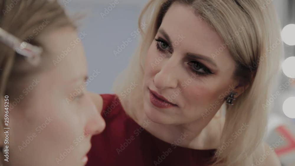 Makeup artist applies professional makeup to a beautiful young girl. New concept in makeup. Makeup artist applies professional makeup to a beautiful young girl. New concept in makeup.