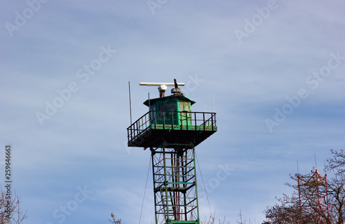 Metal green radio tower on the Baltic sea beach