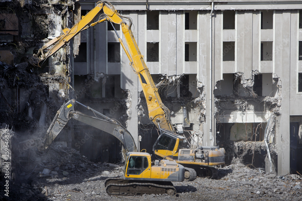 Building of the former hotel demolition for new construction, using a two special hydraulic excavator-destroyer. Complete highly mechanized demolition of building structures. Construction site Building of the former hotel demolition for new construction, using a two special hydraulic excavator-destroyer. Complete highly mechanized demolition of building structures. Construction site