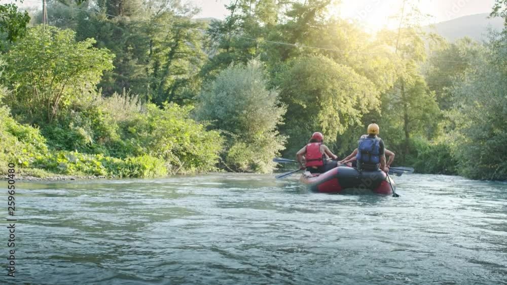 Group of people on raft boat doing rafting on river during sunset or sunrise. Warm back light. Friends italian trip in Umbria.4k slow motion Group of people on raft boat doing rafting on river during sunset or sunrise. Warm back light. Friends italian trip in Umbria.4k slow motion