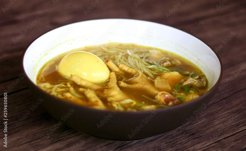 Soto ceker or chicken feet soup on wood background. 