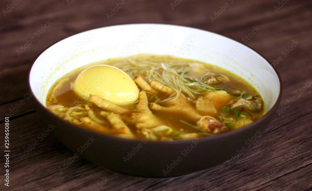 Soto ceker or chicken feet soup on wood background. Soto ceker or chicken feet soup on wood background.