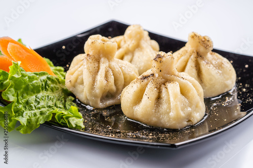 Georgian dumplings Khinkali with meat and red papper, on brown plate