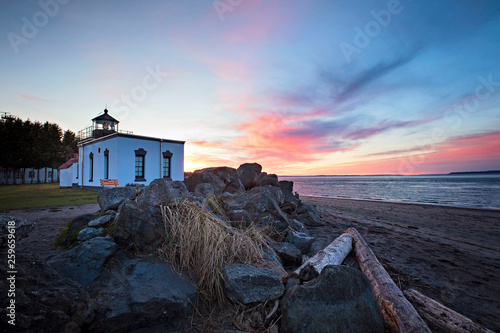 lonely evening watching the sunset set at the point no point lighthouse near kingston, washington state, puget sound, pacific northwest photo