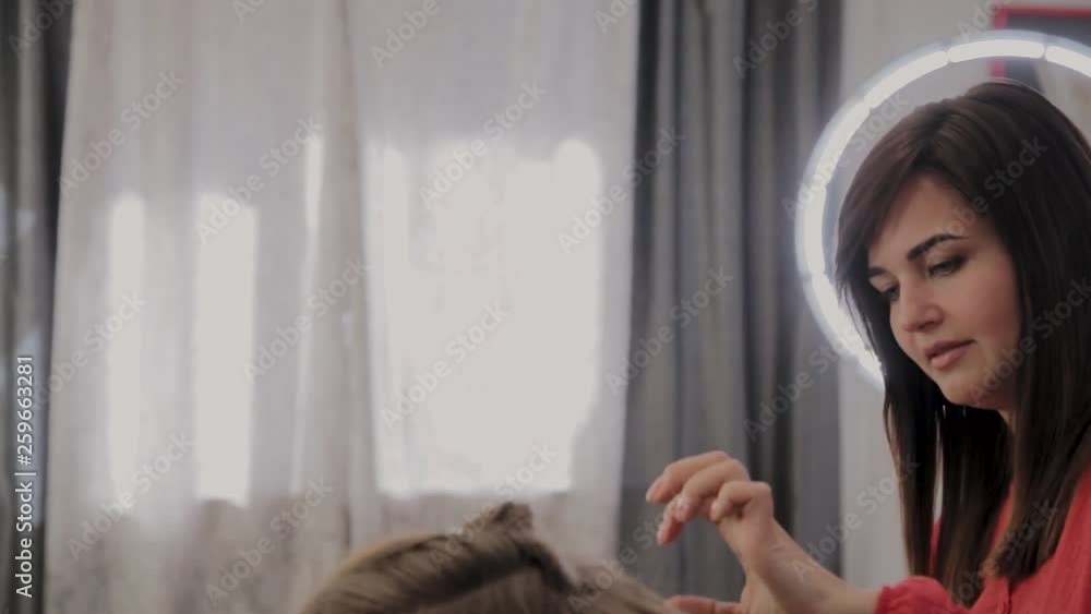 Professional hairdresser does a girl's hairstyle for a photo shoot. Professional hairdresser does a girl's hairstyle for a photo shoot.