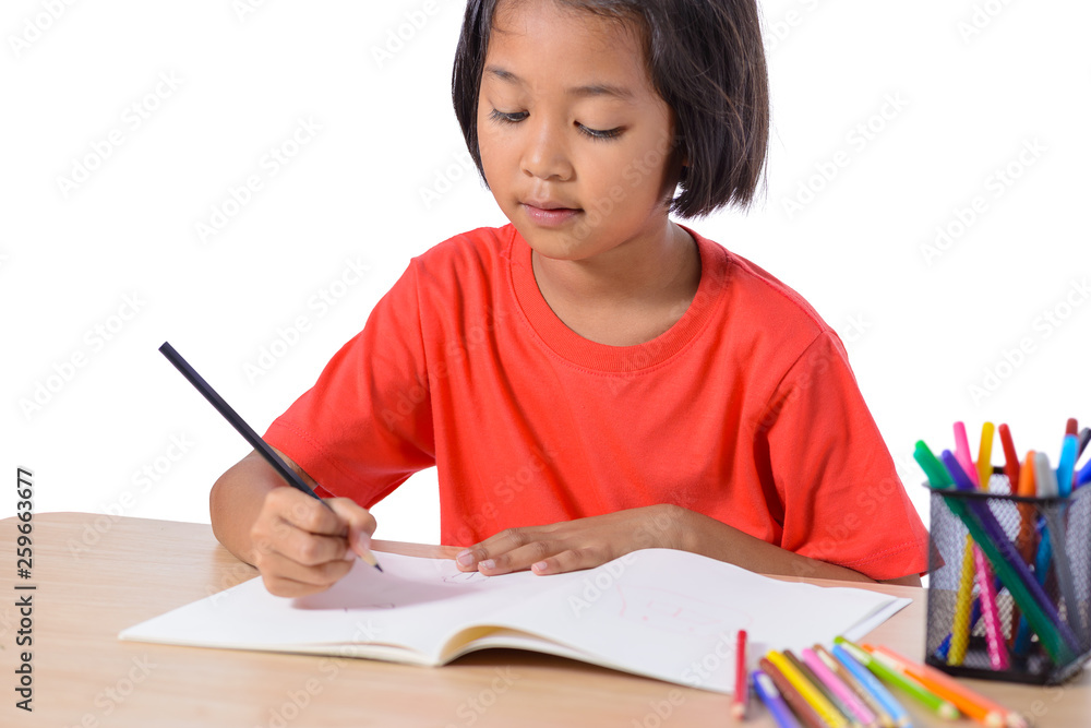 Cute cheerful child drawing using color pencil while sitting at table isolated on white background Cute cheerful child drawing using color pencil while sitting at table isolated on white background