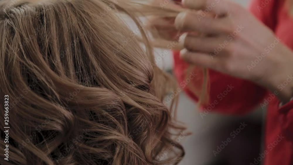 Professional hairdresser does a girl's hairstyle for a photo shoot. Professional hairdresser does a girl's hairstyle for a photo shoot.