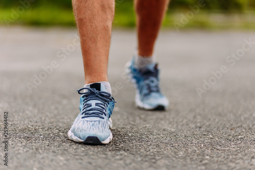 running shoes on men's feet on asphalt