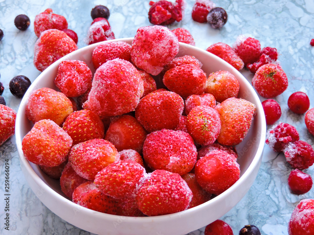 Frozen berries.Top view. Frozen delicious berries on blue background, closeup. Assorted frozen berries background. Raspberries, black currant and strawberries on blue background, copy space. Frozen berries.Top view. Frozen delicious berries on blue background, closeup. Assorted frozen berries background. Raspberries, black currant and strawberries on blue background, copy space.
